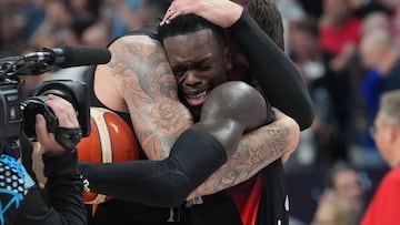 Germany's point guard #17 Dennis Schroder (R) is hugged by a team player after winning the FIBA EuroBasket 2025 final basketball match between Turkey and Germany in Riga, Latvia, on September 12, 2025.