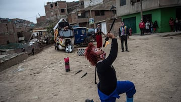 A clown performs at Puente Piedra district, in the northern outskirts of Lima on August 03, 2020, during the COVID-19 pandemic. - Due to the coronavirus pandemic, circuses in Peru remain closed, leading this group of clowns traveling in their mototaxi circus to perform in the streets of Lima. (Photo by Ernesto BENAVIDES / AFP)