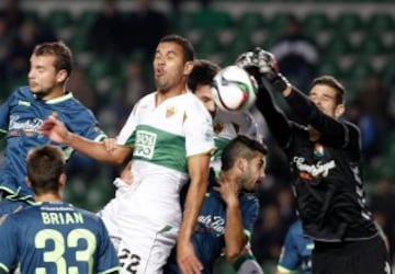 El delantero del Elche Jonathas de Jesus (c) intenta rematar ante el portero venezolano del del Real Valladolid Dani Hernández (d) durante el partido de vuelta de dieciseisavos de final de la Copa del Rey, disputado esta tarde en el estadio Martínez Valero.