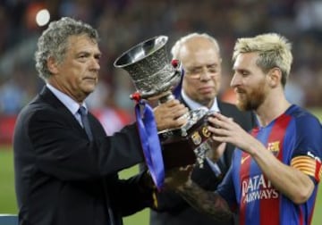 El capitán del FC Barcelona, Leo Messi recibe el trofeo de campeón de la Supercopa de España de manos del presidente de la FEF Ángel María Villar tras vencer por 3-0 al Sevilla FC en el partido de vuelta de la Supercopa de España 