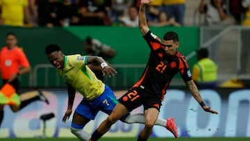 AME1064. BRASILIA (BRASIL), 20/03/2025.- Vinicius Jr. (i) de Brasil disputa el balón con Daniel Muñoz de Colombia este jueves, en un partido de las eliminatorias sudamericanas al Mundial de 2026 entre las selecciones de Brasil y Colombia, en el estadio Arena BRB Mané Garrincha, en Brasilia (Brasil). EFE/ Andre Coelho
