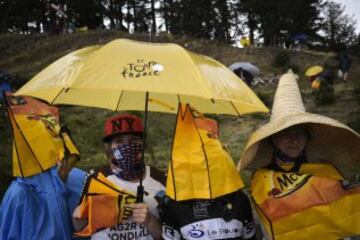 Espectadores se protegen de la lluvia.