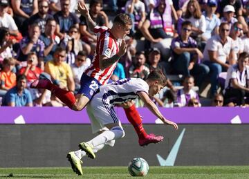 El jugador del Atlético de Madrid, Kieran Trippier, trata de parar al jugador del Real Valladolid, Toni. 