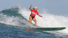 Laura Blears surfeando una ola con el pelo blanco, ya de mayor, en Hawái.