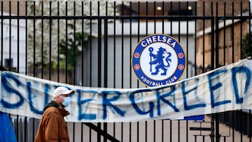 A pedestrian walks past an anti-European Super League banner reading "Supergreed" outside an entrance to Stamford Bridge football stadium in London on April 20, 2021, ahead of the English Premier League match between Chelsea and Brighton and Hov