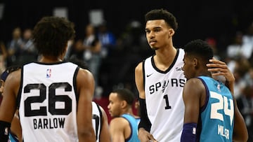 San Antonio Spurs' Victor Wembanyama (C) stands with Charlotte Hornets' Brandon Miller (R) and San Antonio Spurs' Dominick Barlow (L) at the end of the NBA Summer League game between the San Antonio Spurs and Charlotte Hornets, at the Thomas and Mack Center in Las Vegas, Nevada, on July 7, 2023. (Photo by Patrick T. Fallon / AFP)