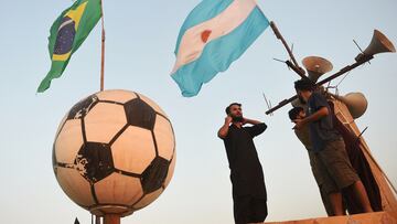 Football fans install flags of Brazil (L) and Argentina ahead of Qatar 2022 FIFA World Cup football tournament on the rooftop of a house in Karachi on November 12, 2022. (Photo by Rizwan TABASSUM / AFP)