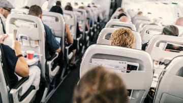 Interior of commercial airplane with passengers in their seats during flight.