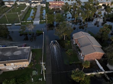 Una vista aérea de un dron muestra un automóvil circulando por una calle inundada después de que el huracán Milton tocara tierra en el sur de Daytona.