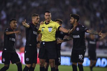 Players of Argentine team Lanus demand Colombian referee Wilmar Roldan to award them a penalty during the Copa Libertadores semifinal first leg football match against Argentina's River Plate in Lanus, on the outskirts of Buenos Aires, on October 31, 2017. / AFP PHOTO / Eitan ABRAMOVICH