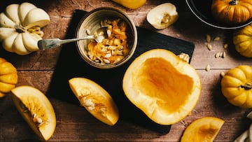 Rustic dark still life with sliced pumpkin and seeds in autumn kitchen
