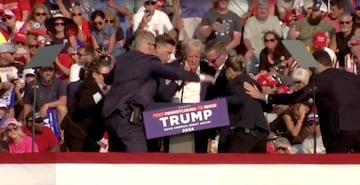 El expresidente, Donal Trump, es evacuado por el servicio secreto del estrado, con algo de sangre  en el rostro, tras escucharse disparos. El candidato republicano ha salido por su propio pie con el puño en alto.