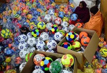 Los balones de fútbol, que se fabrican para la exportación y el mercado indio, son confeccionados por pequeños contratistas en Jalandhar, India. Los dueños de las fábricas distribuyen las materias primas entre los trabajadores de los barrios más marginales de la ciudad que cosen los balones en sus casas.