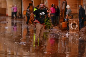 Un hombre reacciona frente a casas afectadas por las inundaciones en Utiel, España.