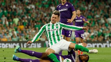 SEVILLA, 01/05/2025.- El centrocampista argentino del Betis, Giovani Lo Celso, cae ante el defensor de la Fiorentina durante el partido de ida de las semifinales de la Liga Conferencia que Real Betis y ACF Fiorentina disputan este jueves en el estadio Benito Villamarín, en Sevilla. EFE/Julio Muñoz