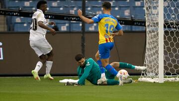 RIAD (ARABIA SAUDÍ), 11/01/2023.- El portero del Valencia Giorgi Mamardashvili (c) intercepta un balón ante Vinicius Junior, del Real Madrid, durante el encuentro de semifinales de la Supercopa de España que se disputa este miércoles en el Estadio Internacional Rey Fahd, en Riad (Arabia Saudí). EFE/Juan Carlos Cárdenas