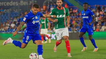 GETAFE (MADRID), 28/08/2023.- El centrocampista del Getafe Cristian Portu (i) juega un balón ante Luis Rioja (c), del Alavés, durante el partido de LaLiga que disputan este lunes Getafe CF y Deportivo Alavés en el Coliseum Alfonso Pérez. EFE/Fernando Alvarado
