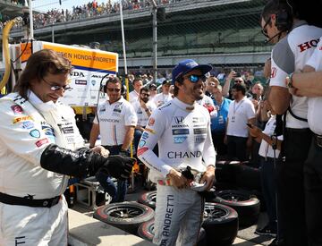El piloto español Fernando Alonso habla con los miembros de su equipo durante la última sesión de entrenamientos previos a la disputa, este domingo 28, de las 500 Millas de Indianápolis.