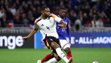(FILES) Germany's defender #04 Jonathan Tah (L) passes the ball ahead of France's forward #11 Ousmane Dembele (R) during the friendly football match between France and Germany, at the Groupama Stadium in Decines-Charpieu, near Lyon, on March 23, 2024. The German Football Association (DFB) said on April 1, 2024 it would change the typeface used on its shirts after one of the kit numbers drew comparisons to a Nazi symbol. The number four worn by national team players was said to bear a resemblance to the insignia of the Nazis' elite SS corps. (Photo by FRANCK FIFE / AFP)