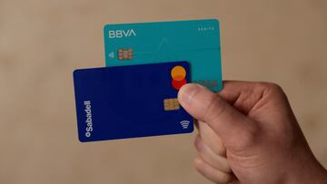FILE PHOTO: A man shows his debit cards of BBVA and Sabadell banks, in Ronda, Spain, May 9, 2024. REUTERS/Jon Nazca/File Photo