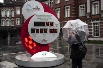 Un hombre hace una fotografía frente a una estación de Tokio de un reloj que muestra la cuenta atrás para los Juegos Olímpicos, cuando faltan 100 días para la ceremonia de apertura. El aplazamiento por el coronavirus ha conseguido que esta posiblemente sea la cita olímpica más deseada.