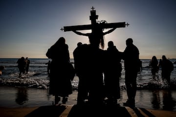 Cofrades llevan la talla de Cristo a la orilla de la playa, a 7 de abril de 2023, en Valencia, Comunidad de Valencia, (España). El Viernes Santo es el día grande de esta festividad con las cofradías del Cristo del Salvador y del Amparo, que se desplazan al mar Mediterráneo para rezar una oración por todos los ahogados en el mar, pescadores, marineros y migrantes. Mientras tanto, en la orilla el personaje bíblico representando a la Madre Dolorosa deposita flores sobre las olas.