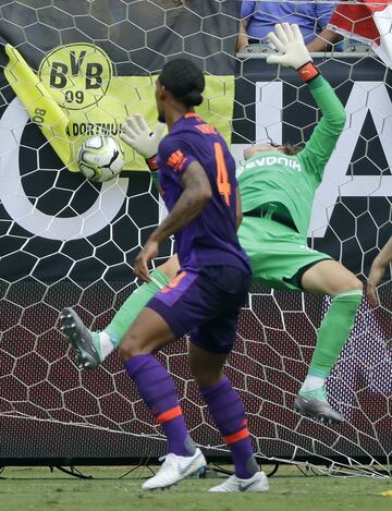 Liverpool's Virgil van Dijk (4) heads the ball past Borussia Dortmund goalkeeper Marwin Hitz (35) during an International Champions Cup tournament soccer match in Charlotte, N.C., Sunday, July 22, 2018. (AP Photo/Chuck Burton)