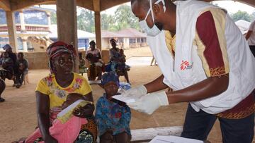 A Doctors Without Borders (MSF) Health worker tends to a mother and her child at a mobile clinic outreach in Manokortuhun village Kenema district July 10, 2020. - Across the impoverished West African state, doctors are warning that disease-prone infants a