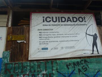 Un cartel de aviso en el departamento de Madre de Dios en el Perú: evitar el contacto, no entregar ciertos objetos y no fotografiarlos, pueden confundir la cámara con un arma.