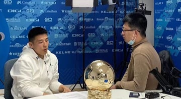 Yan Xu, entrevistando a Wu Lei con el Balón de Oro sobre la mesa.