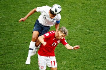 Raphael Varane salta para robar el balón a Jens Stryger Larsen.