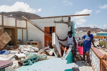 Shermaine Baptiste, izquierda, y una amiga miran su dormitorio destruido después de que fuera azotado por el huracán Beryl en Clifton, Union Island, San Vicente y las Granadinas.