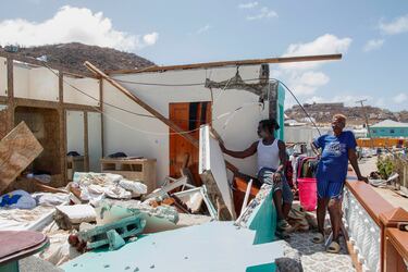 Shermaine Baptiste, izquierda, y una amiga miran su dormitorio destruido después de que fuera azotado por el huracán Beryl en Clifton, Union Island, San Vicente y las Granadinas.