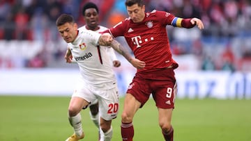 MUNICH, GERMANY - MARCH 05: Robert Lewandowsk of Bayern Munchen tackles with Charles Aranguiz of Leverkusen  during the Bundesliga match between FC Bayern München and Bayer 04 Leverkusen at Allianz Arena on March 05, 2022 in Munich, Germany. (Photo by Alex Grimm/Getty Images)