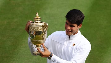 Tennis - Wimbledon - All England Lawn Tennis and Croquet Club, London, Britain - July 14, 2024 Spain's Carlos Alcaraz celebrates with the trophy after winning the men's singles final against Serbia's Novak Djokovic REUTERS/Matthew Childs