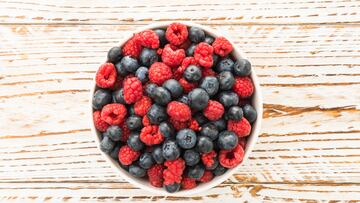 Group of Blueberry and Rasberry fruit in bowl on wooden background