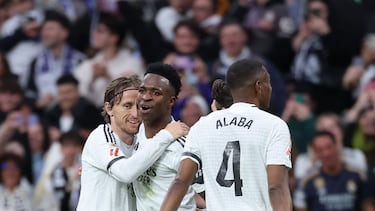 Real Madrid's Brazilian forward #07 Vinicius Junior (C) celebrates with Real Madrid's Croatian midfielder #10 Luka Modric after scoring his team's second goal during the Spanish league football match between Real Madrid CF and Rayo Vallecano de Madrid at the Santiago Bernabeu stadium in Madrid on March 9, 2025. (Photo by Thomas COEX / AFP)