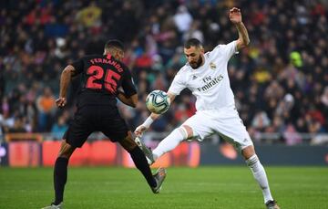 Real Madrid's French forward Karim Benzema vies with Sevilla's Brazilian midfielder Fernando (L) during the Spanish league football match between Real Madrid CF and Sevilla FC