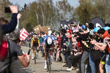 Grupos de aficionados animan al ciclista neerlandés del Alpecin-Deceuninck, Mathieu Van Der Poel, y al belga del Jumbo-Visma, Wout Van Aert , rodeados de polvo en un sector de la carrera.