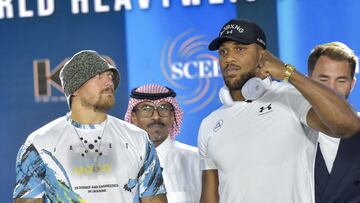Ukraine's Oleksandr Usyk (L) and Britain's Anthony Joshua (R) pose for a picture during the press conference to announce the heavyweight boxing rematch for the WBA, WBO, IBO and IBF titles in Jeddah on June 21, 2022. - The match, billed as Rage on the Red Sea, is set to take place on August 20, 2022, at the Jeddah Super Dome. (Photo by Amer HILABI / AFP)