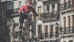 Piloto de MTB sobre rampa del festival en Vigo, con edificios, sombrillas y gentes al fondo. 