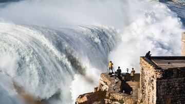 TOPSHOT - Spectators gather to watch a surfing session in Nazare where a giant swell generated by Epsilon was expected on October 29, 2020 amid the coronavirus pandemic. (Photo by CARLOS COSTA / AFP)