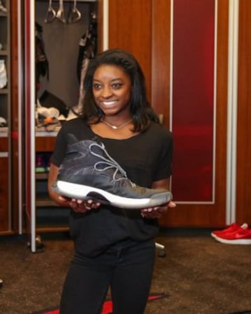 Simone Biles sujeta la zapatilla de Robin Lopez, jugador de los Chicago Bulls.