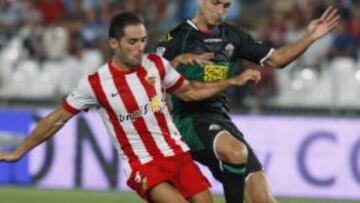 El defensa de la UD Almería, Ángel Trujillo, lucha el balón con Manu del Moral, del Elche CF, durante el partido, correspondiente a la tercera jornada de Liga en Primera División, que los dos equipos disputan esta noche en el estadio de los Juegos Mediterráneos, en Almería.