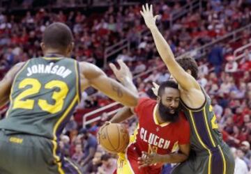 James Harden intenta driblar a Chris Johnson y Raul Neto.