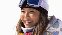 La snowboarder Chloe Kim vestida en tonos morados, con las gafas sobre el gorro, sonriendo. 