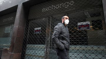 A man wearing a face mask as a protective measure against the coronavirus disease (COVID-19) walks past a closed currency exchange shop, in downtown Buenos Aires, Argentina May 22, 2020.