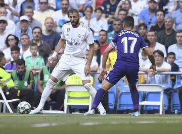 El jugador del Real Madrid, Benzema, trata de controlar el balón ante el jugador del Real Valladolid, Moyano. 