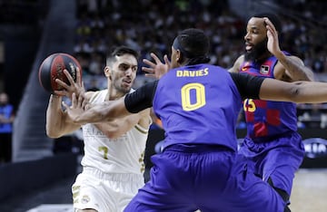 El jugador del Real Madrid, Campazzo, trata de mover el balón ante el jugador del Barcelona, Davies. 