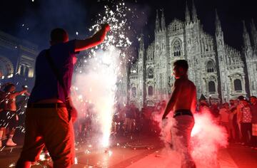 Los aficionados italianos celebran la victoria de su selección en la plaza del Duomo en Milán.